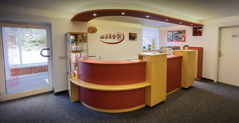 Empfangsbereich der Physiotherapie Beyer in Schmölln-Putzkau mit geschwungenem Tresen und freundlicher Atmosphäre