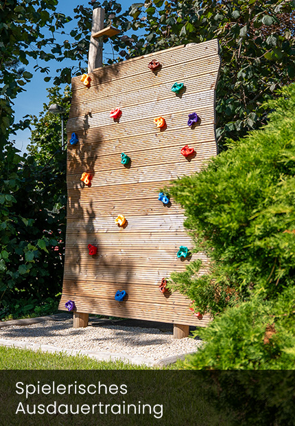 Kletterwand mit bunten Griffen im Außenbereich der Physiotherapie Beyer in Schmölln-Putzkau für die Kindertherapie im Freien